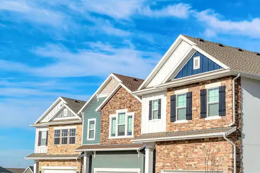 A row of houses with blue sky in the background.